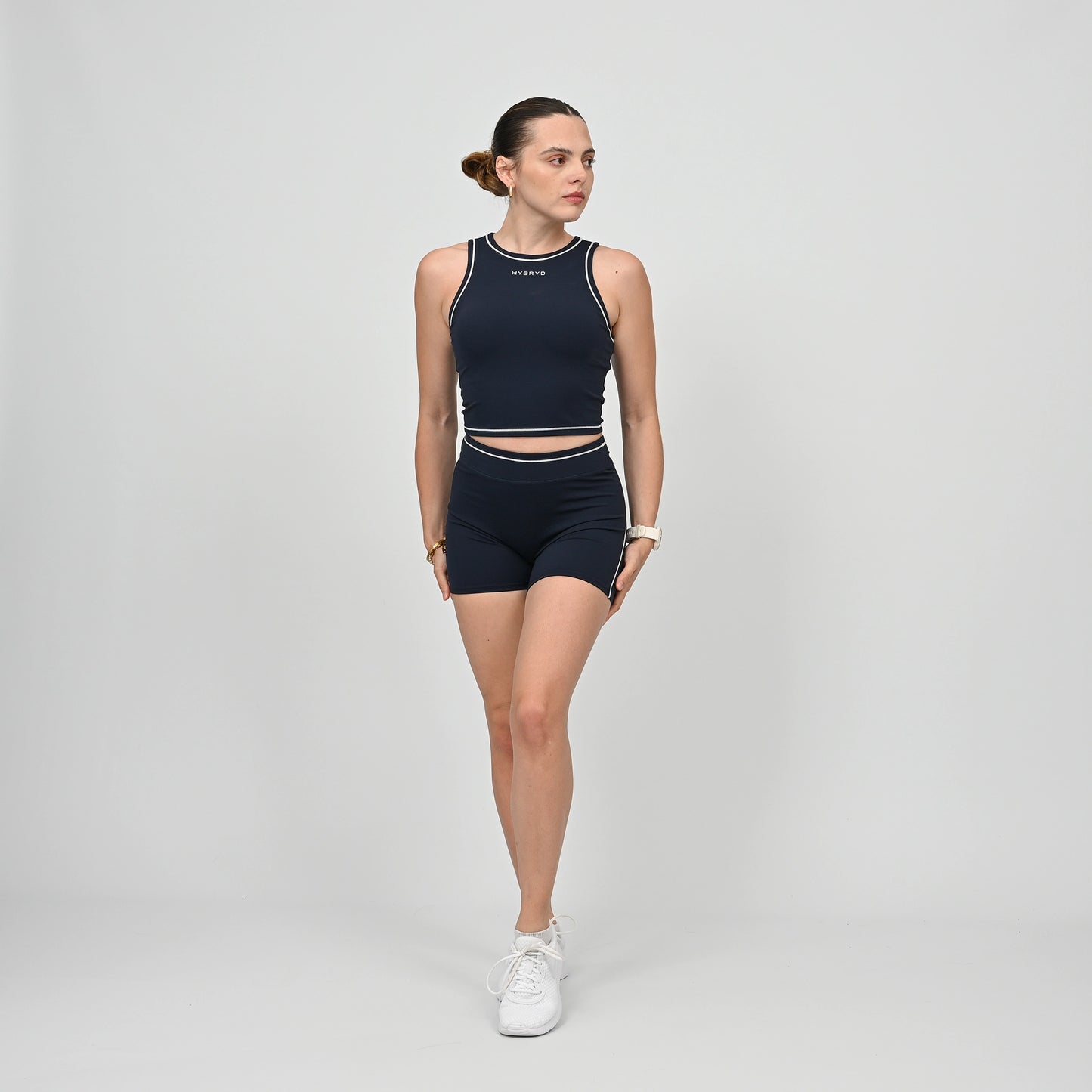Hyrox model wearing a navy athletic gym top and shorts from Hybryd with white contrast piping.