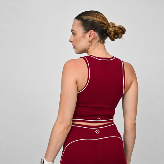 Crossfit athlete wearing a red Hybryd outfit with white piping on a gray background