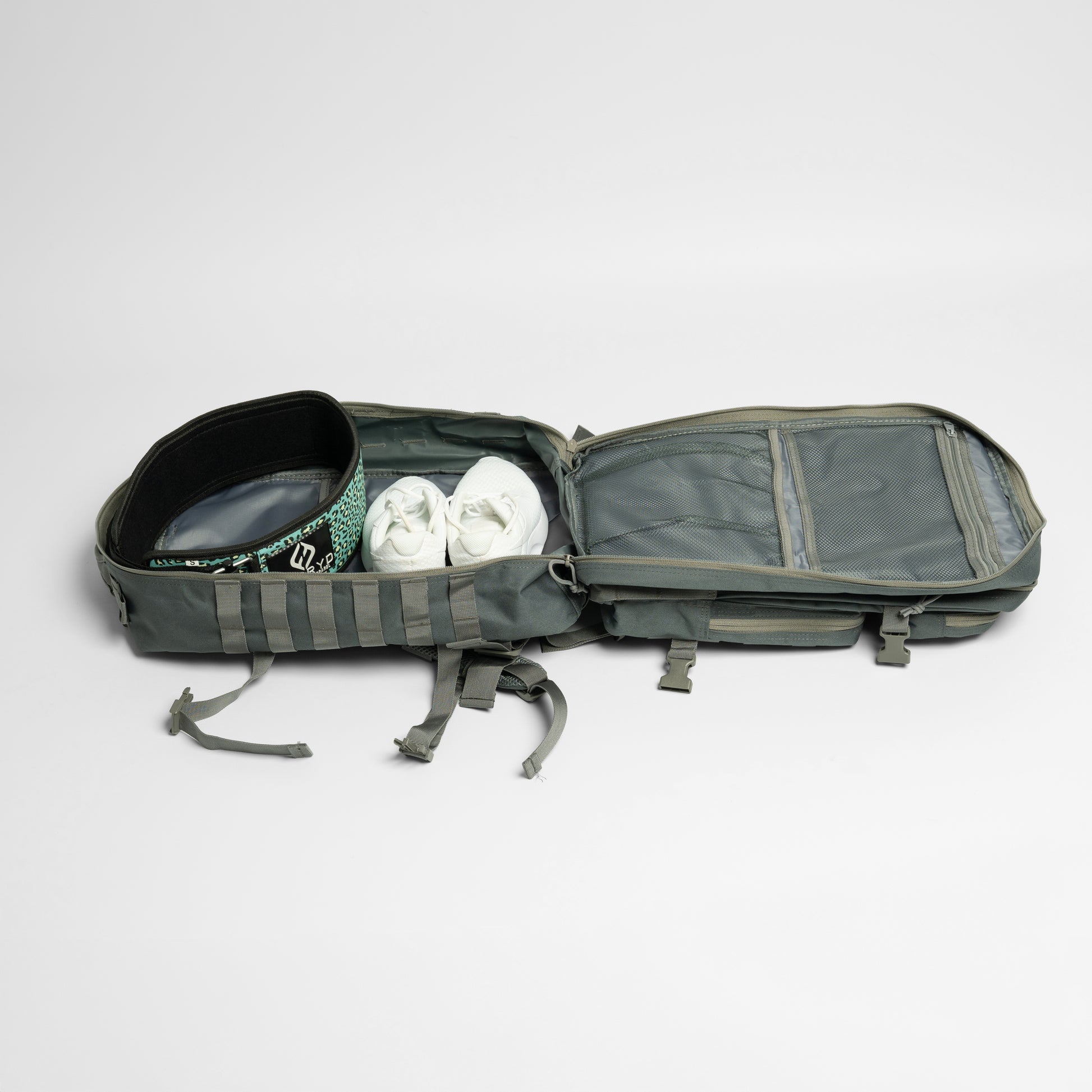 Open gray backpack with shoes inside on a light gray background