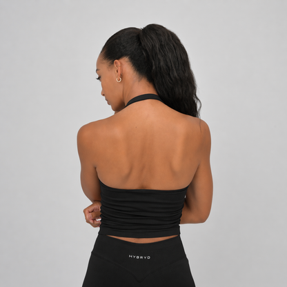 Woman wearing a black sports bra and leggings with 'HYBRYD' branding on a grey background