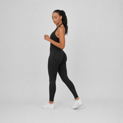 Woman wearing a black athletic gym outfit from Hybryd on a grey background