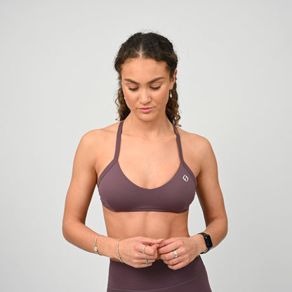 Gym girl wearing a purple minimal sports bra from Hybryd. Comes with adjustable halter neck strap.