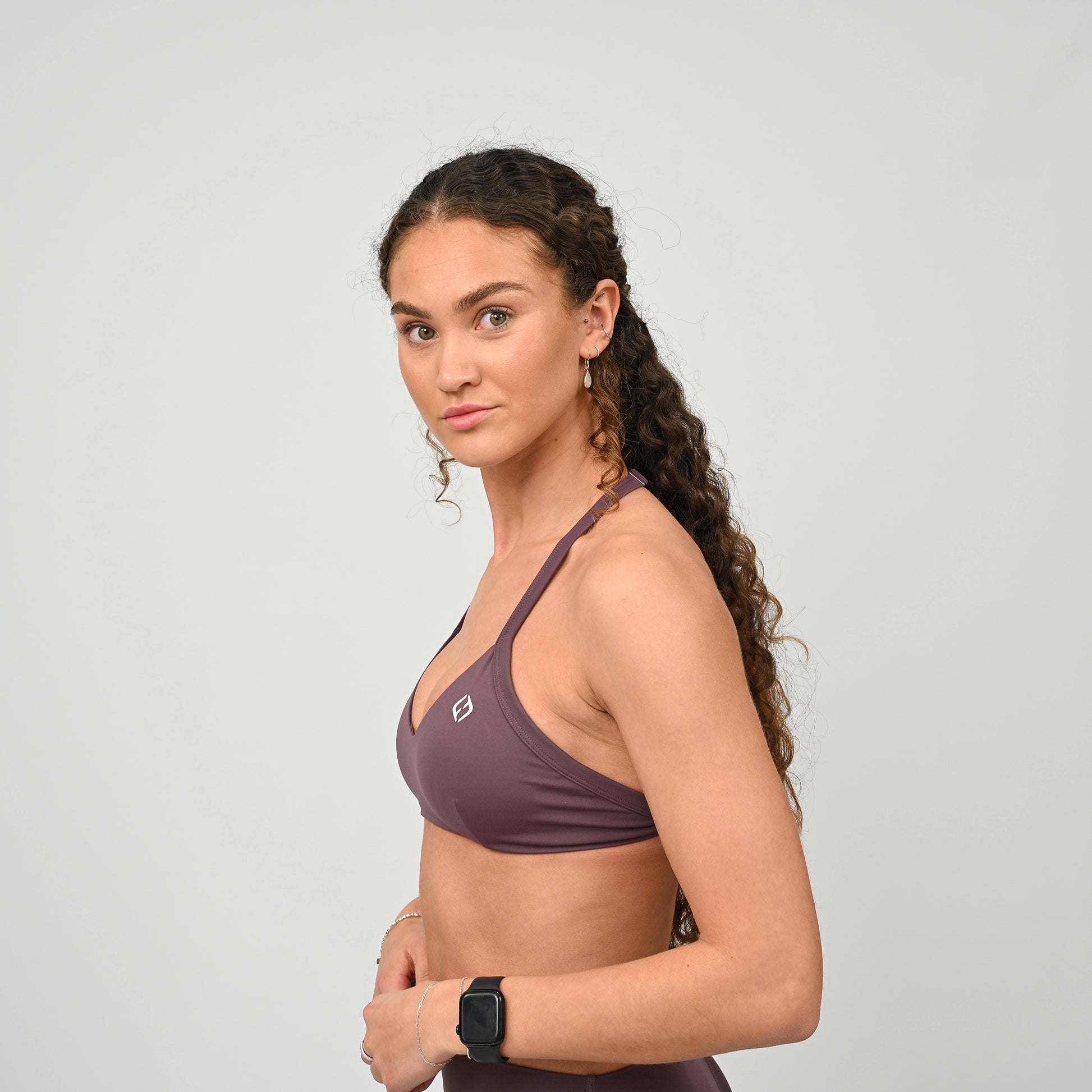 Gym girl wearing a purple minimal sports bra from Hybryd. Comes with adjustable halter neck strap.