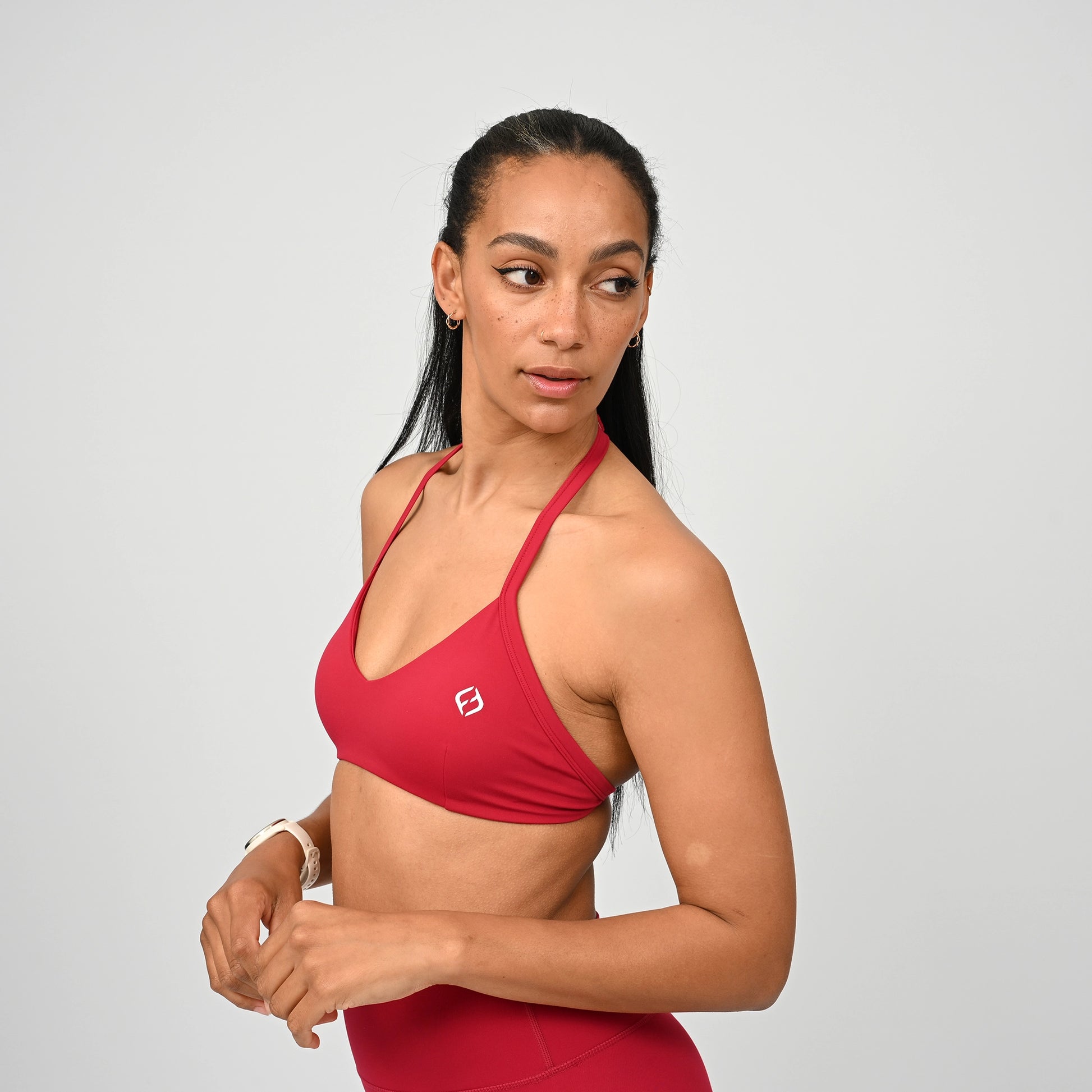 Gym girl wearing a red minimal sports bra from Hybryd. Comes with adjustable halter neck strap.