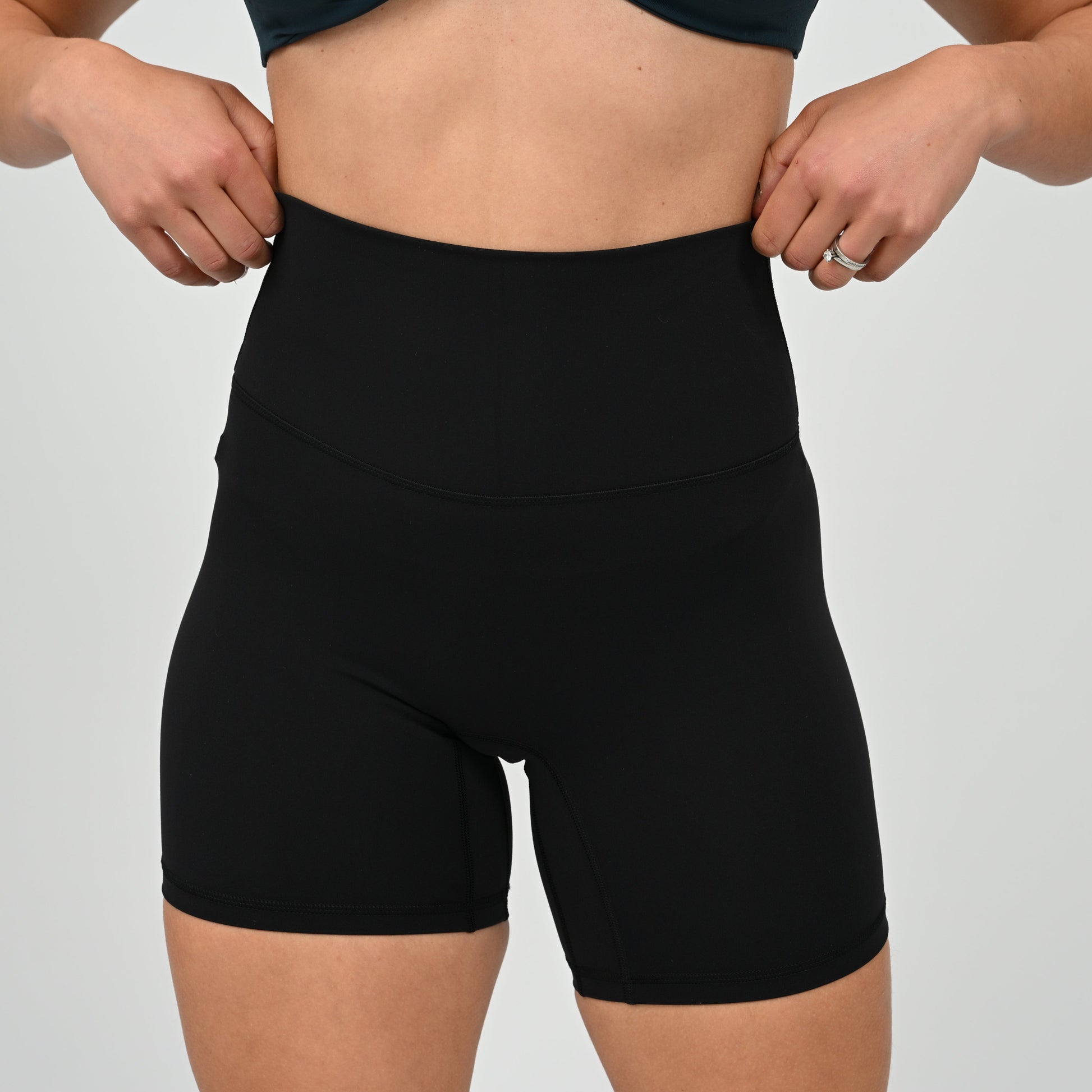 Crossfit girl wearing plain black, high waisted bootie shorts. No cinch. From activewear brand Hybryd.