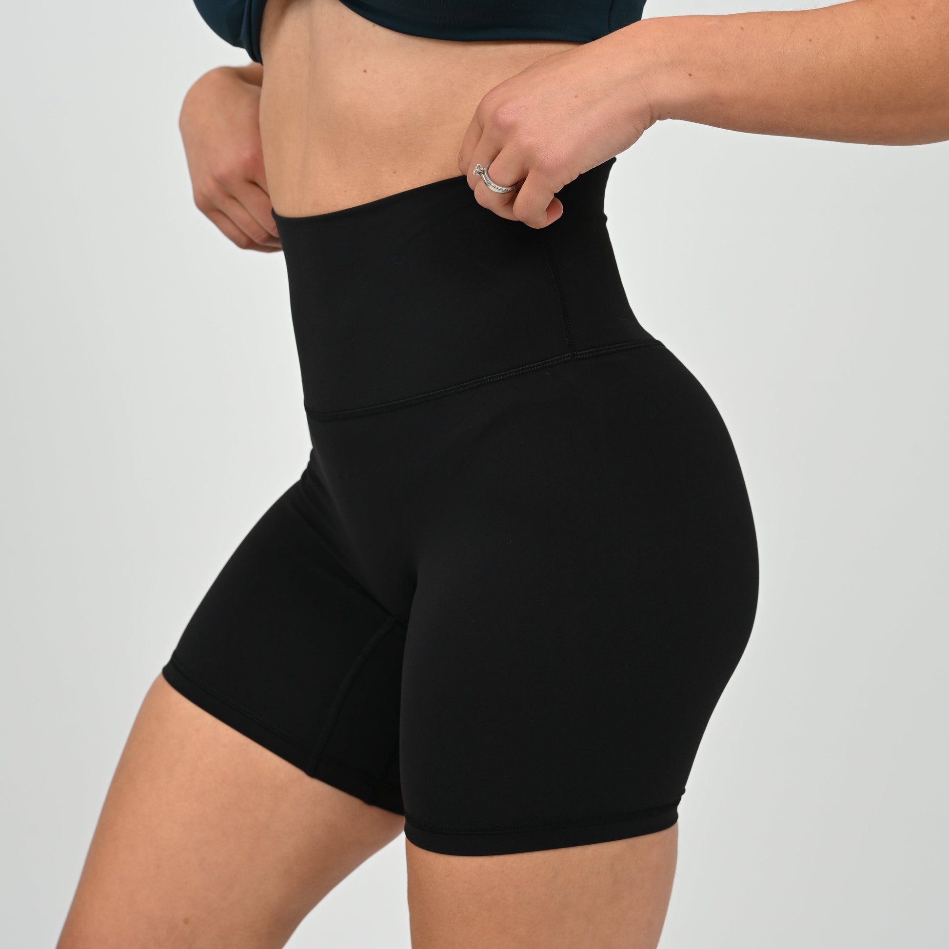 Crossfit girl wearing plain black, high waisted bootie shorts. No cinch. From activewear brand Hybryd.