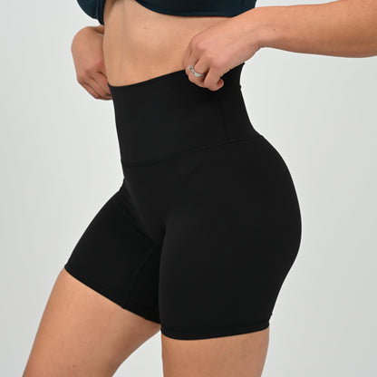 Crossfit girl wearing plain black, high waisted bootie shorts. No cinch. From activewear brand Hybryd.