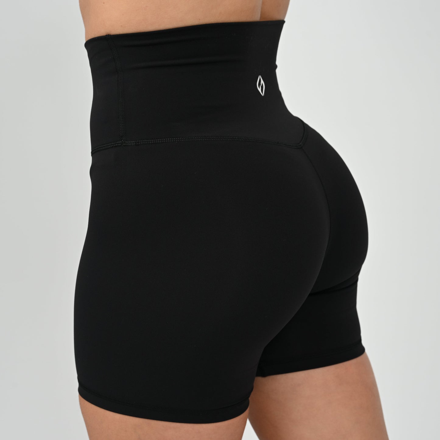 Crossfit girl wearing plain black, high waisted bootie shorts. No cinch. From activewear brand Hybryd.