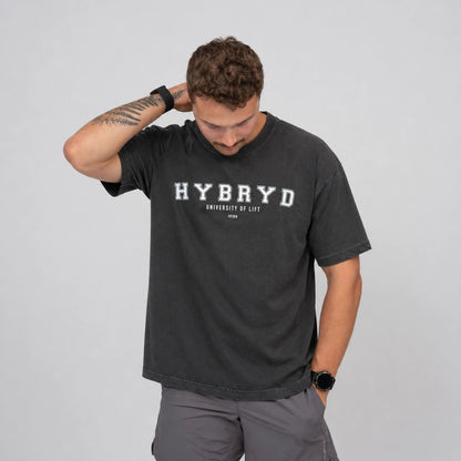 Man wearing a black t-shirt with 'HYBRYD' branding on a grey background