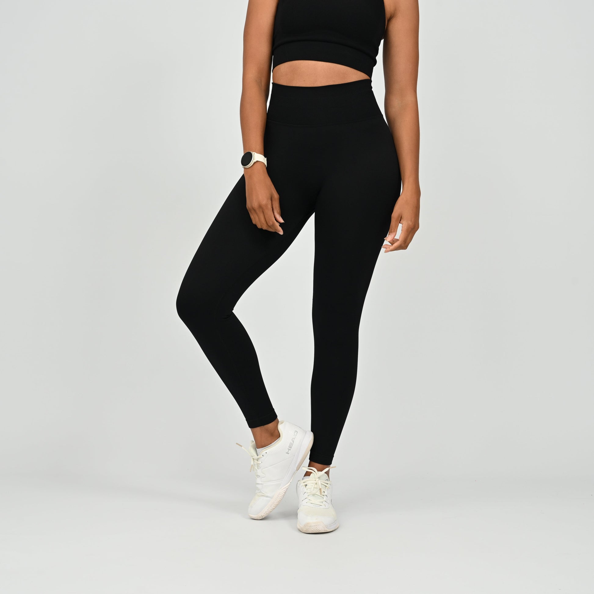 Crossfit athlete wearing plain black hybryd gym leggings. With a cinch bum and contouring. Part of the matching verona activewear set.