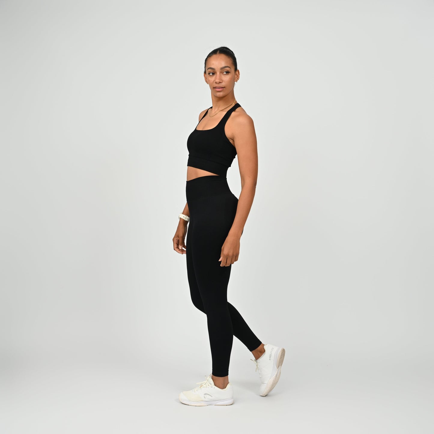 Crossfit athlete wearing plain black hybryd gym leggings. With a cinch bum and contouring. Part of the matching verona activewear set.