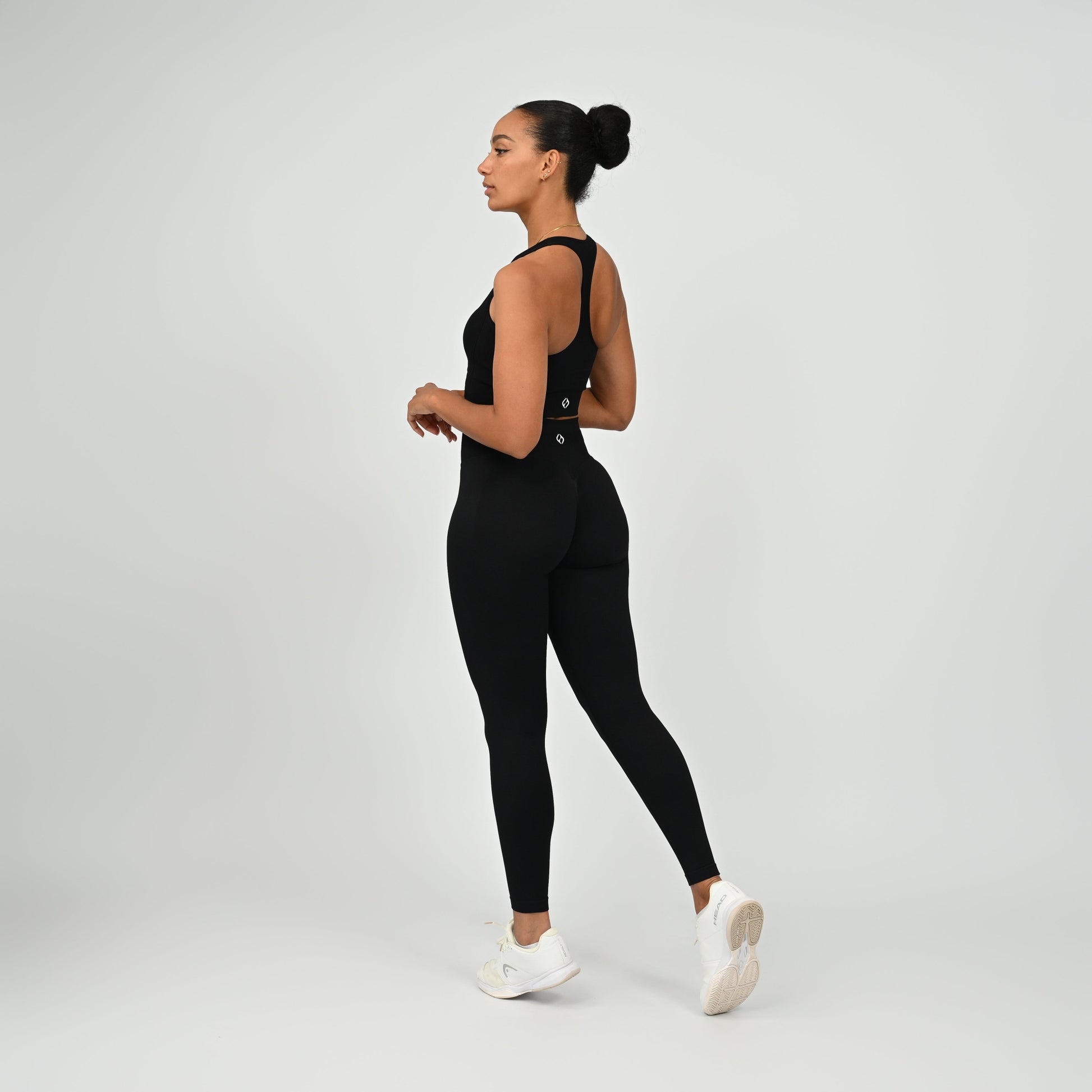 Crossfit athlete wearing plain black hybryd gym leggings. With a cinch bum and contouring. Part of the matching verona activewear set.