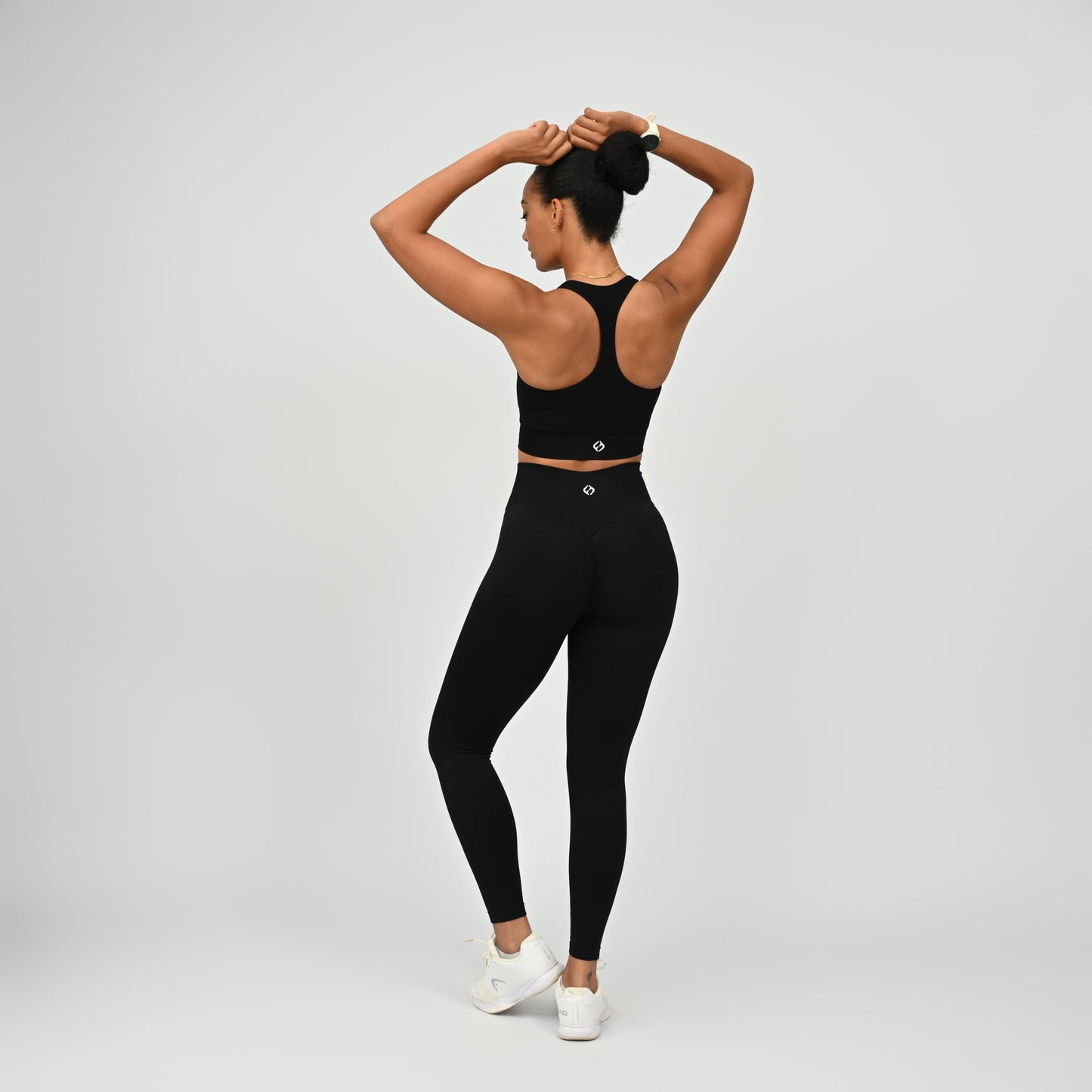 Crossfit athlete wearing plain black hybryd gym leggings. With a cinch bum and contouring. Part of the matching verona activewear set.
