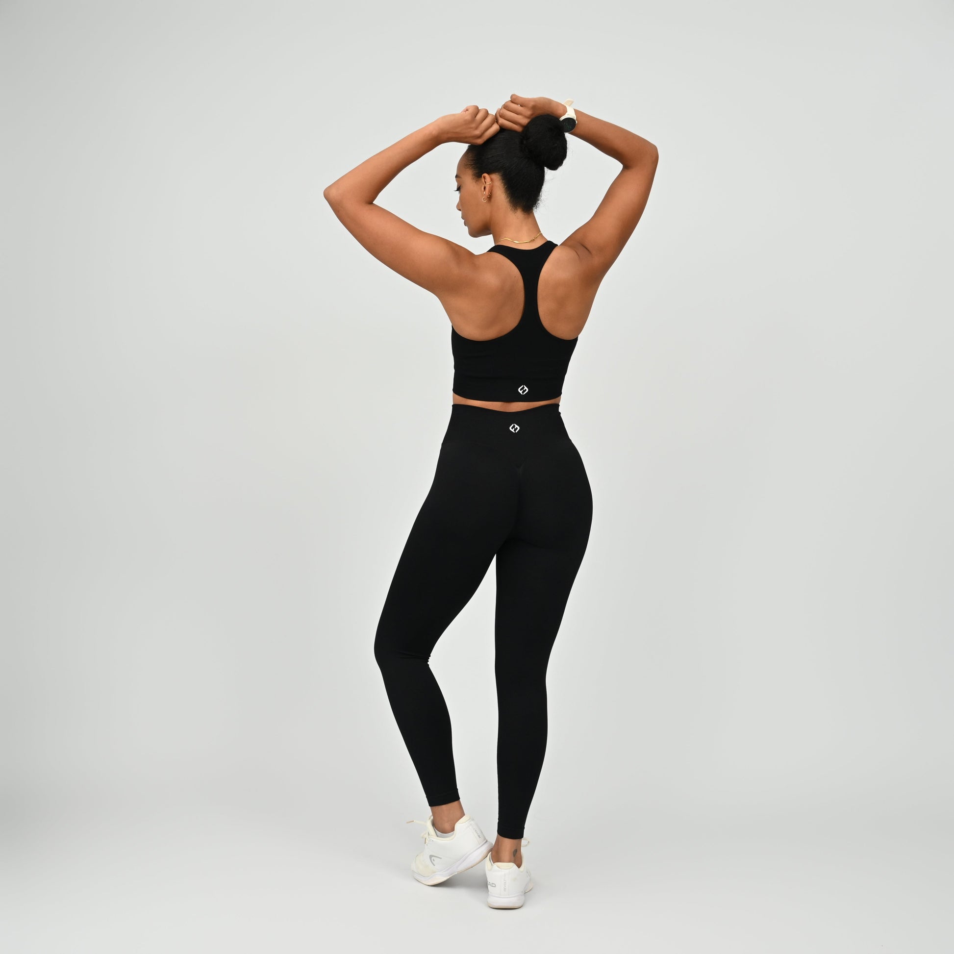 Crossfit athlete wearing plain black hybryd gym leggings. With a cinch bum and contouring. Part of the matching verona activewear set.