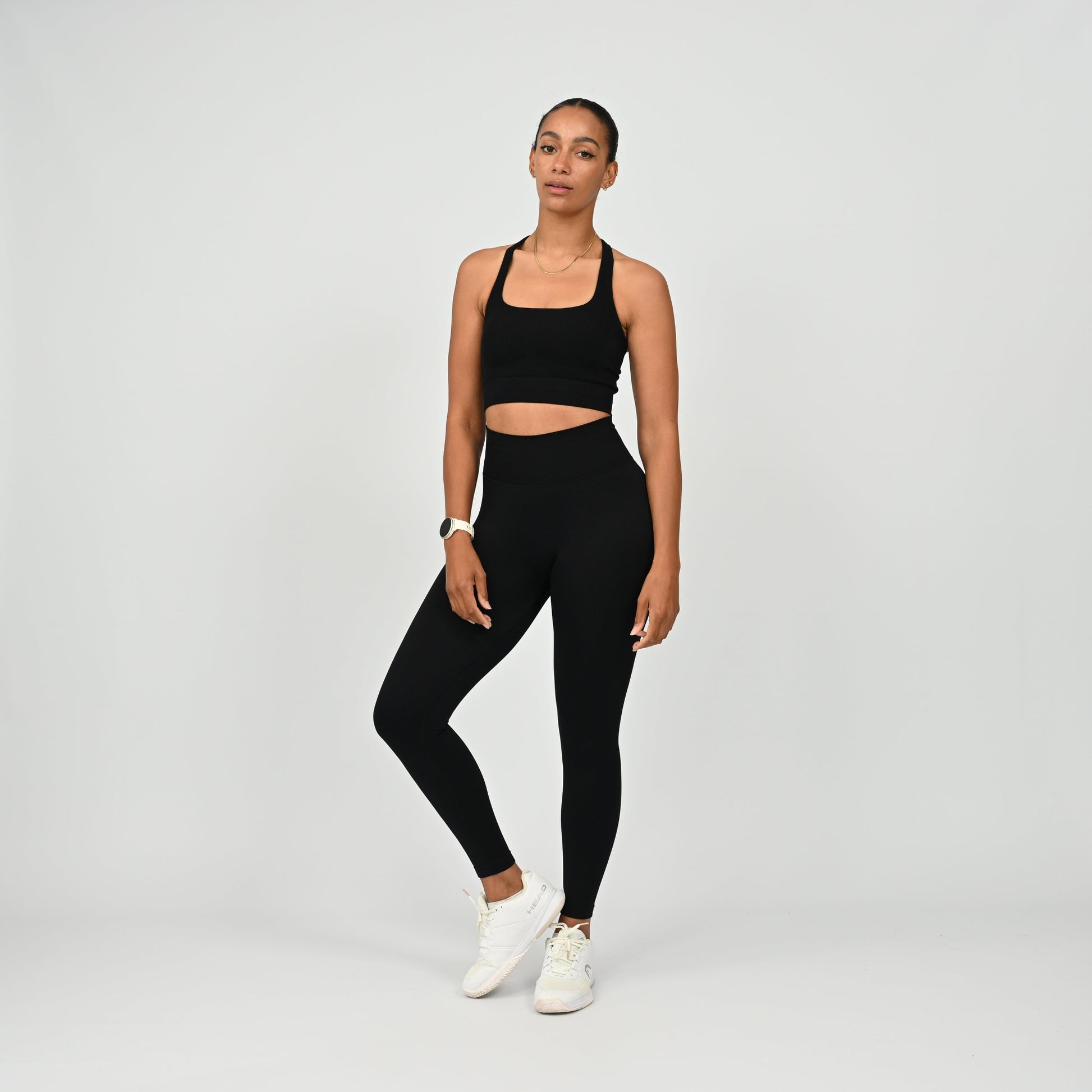 Crossfit athlete wearing plain black hybryd gym leggings. With a cinch bum and contouring. Part of the matching verona activewear set.