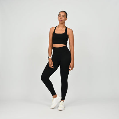 Crossfit athlete wearing plain black hybryd gym leggings. With a cinch bum and contouring. Part of the matching verona activewear set.