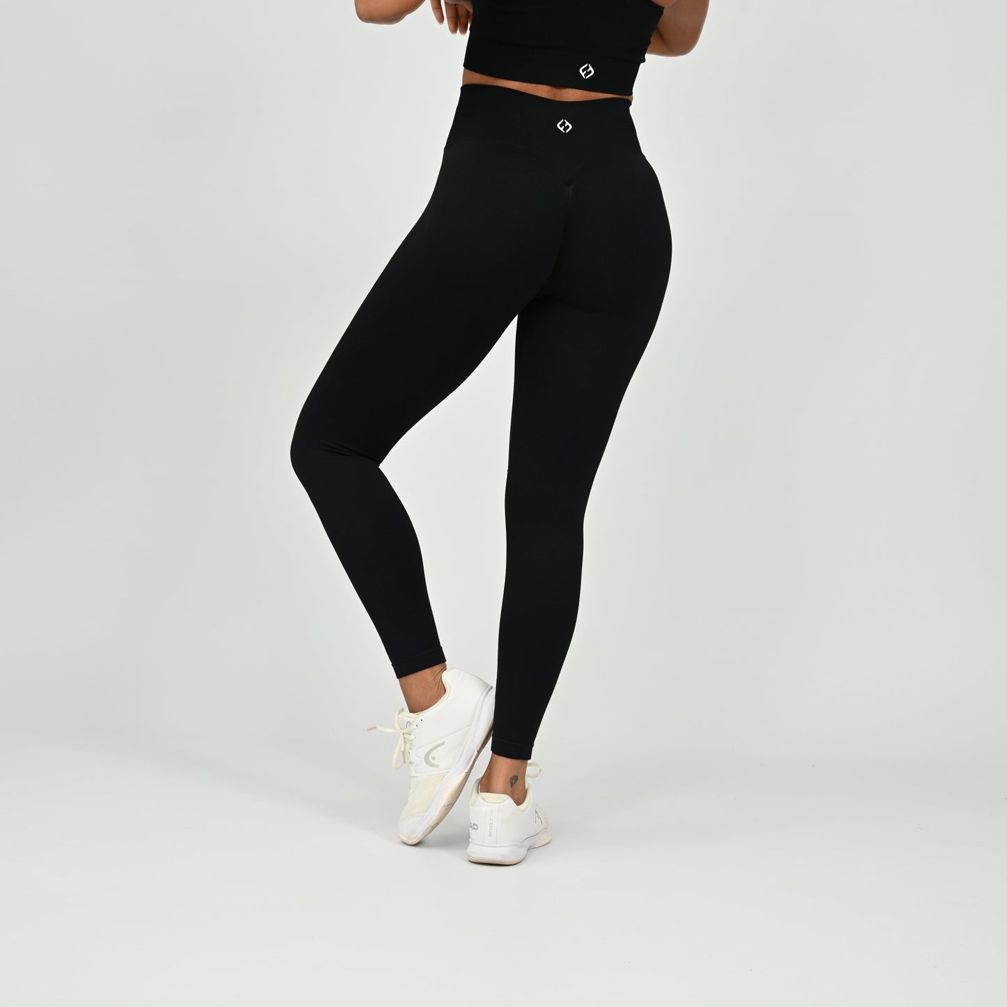 Crossfit athlete wearing plain black hybryd gym leggings. With a cinch bum and contouring. Part of the matching verona activewear set.