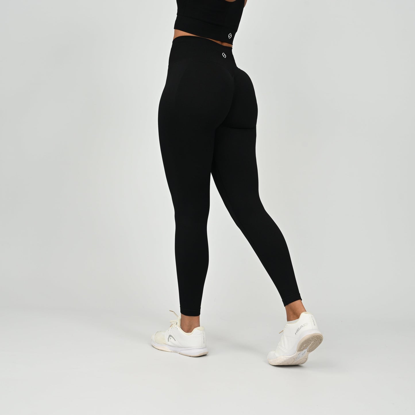 Crossfit athlete wearing plain black hybryd gym leggings. With a cinch bum and contouring. Part of the matching verona activewear set.