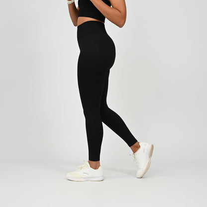 Crossfit athlete wearing plain black hybryd gym leggings. With a cinch bum and contouring. Part of the matching verona activewear set.