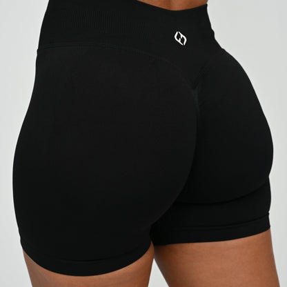 Hyrox woman wearing black, high waisted, cinch bum workout bootie shorts with contouring. Teamed with a matching muscle back sports bra. From activewear brand Hybryd