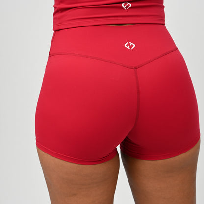 Red Hybryd booty shorts worn by a person on a plain background. 3,5 inch inseam. Non scrunch bum.