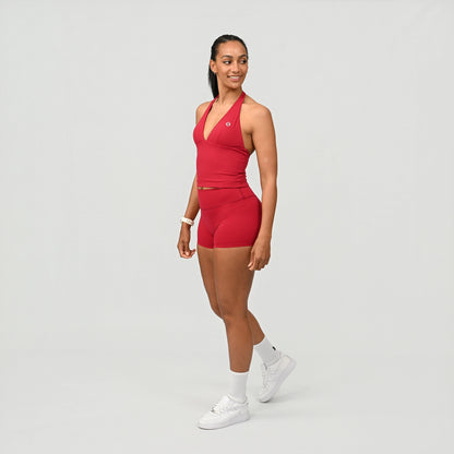 Woman wearing a red athletic Hybryd gym wear outfit on a light gray background