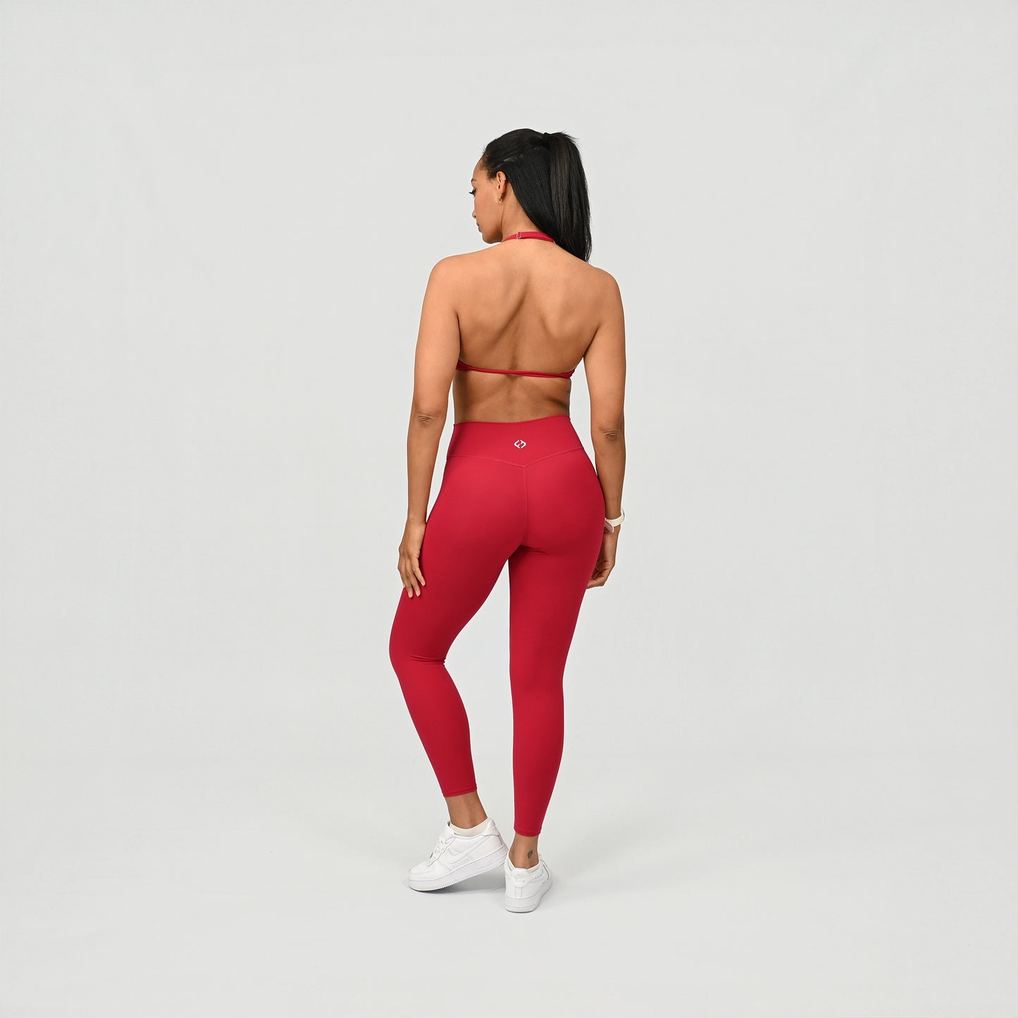 Person wearing red compression leggings on a light gray background