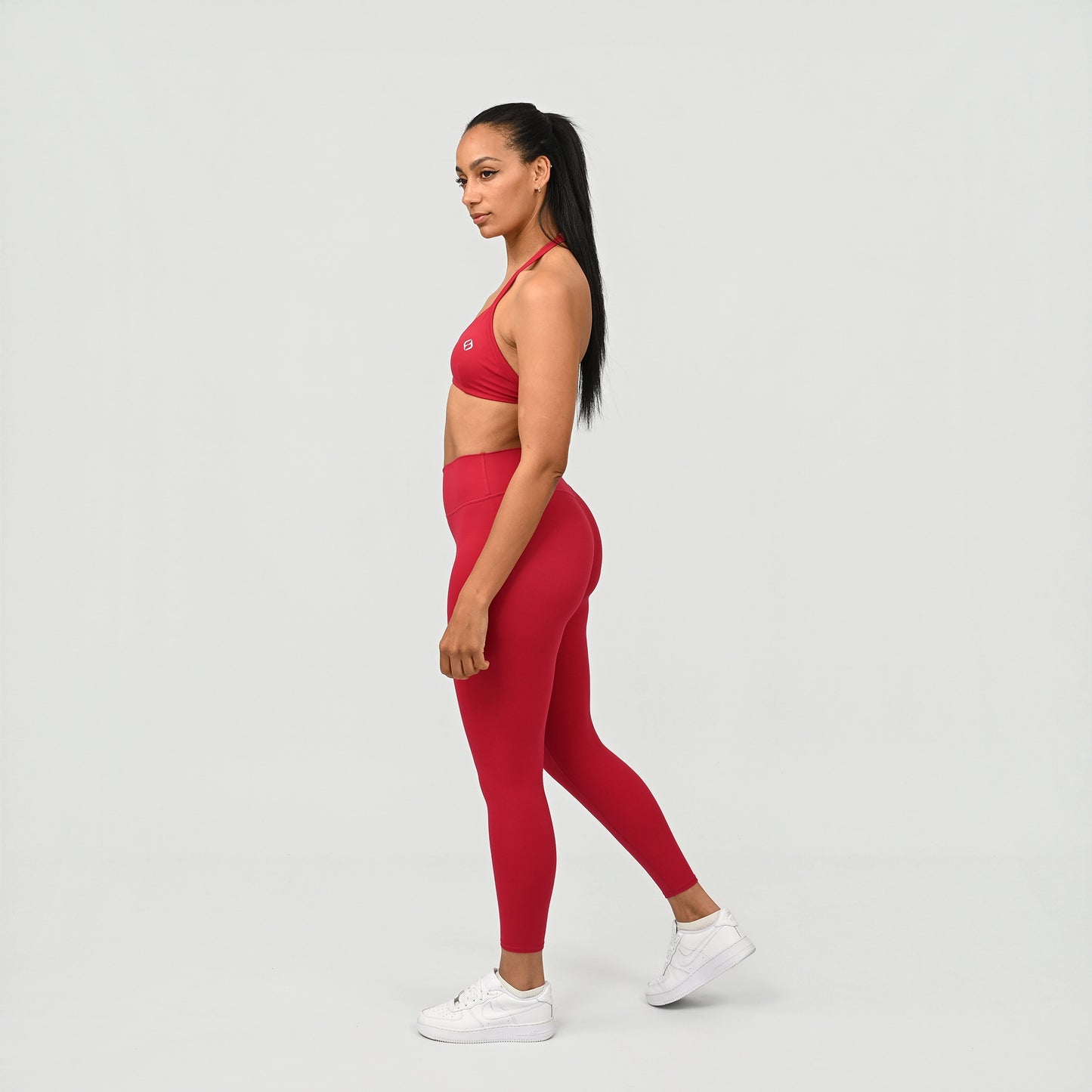 Woman wearing a red athletic Hybryd outfit on a white background