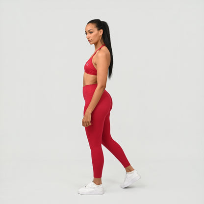 Woman wearing a red athletic Hybryd outfit on a white background