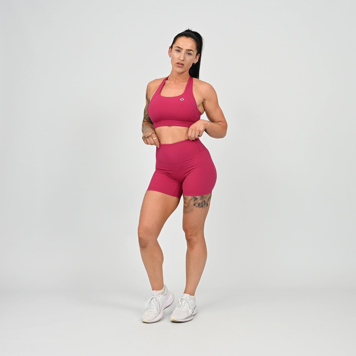 Hyrox girl wearing a raspberry coloured sports bra and cinch bum short. From activewear brand Hybryd.
