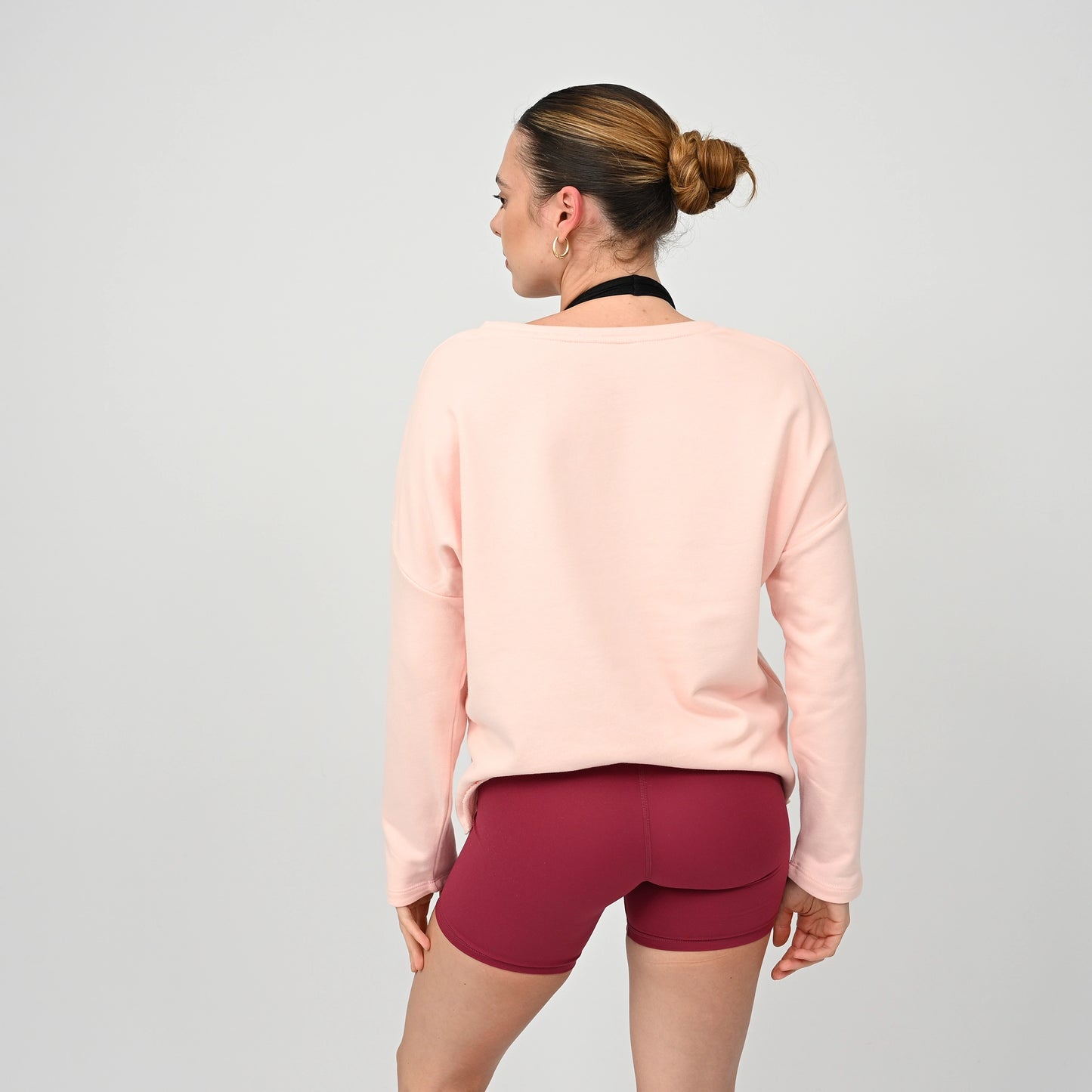 Woman wearing a light pink long-sleeve post workout oversized crew