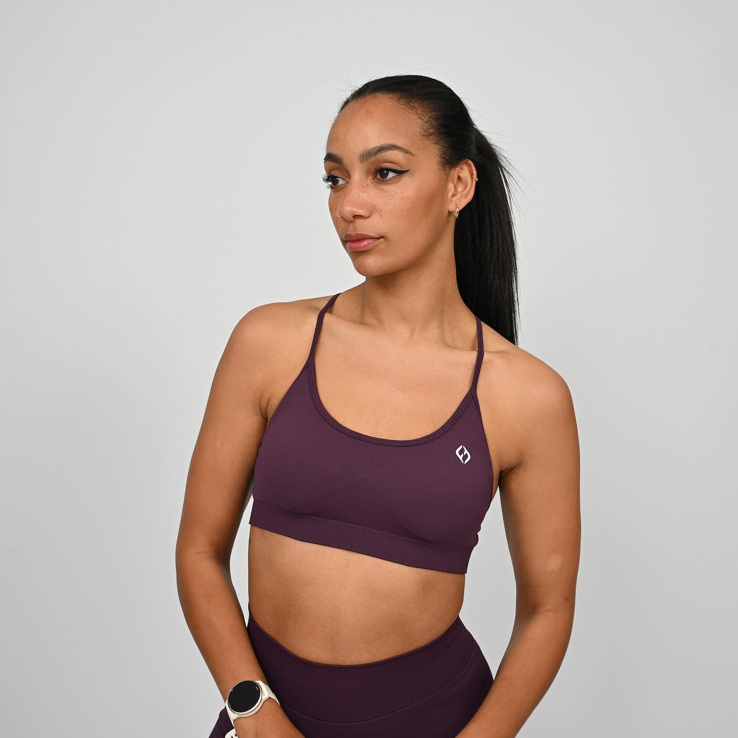 Woman wearing a purple Hybryd sports bra and matching leggings