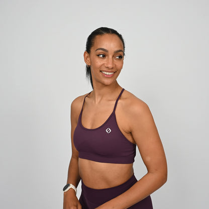 Woman wearing a purple Hybryd sports bra and matching leggings