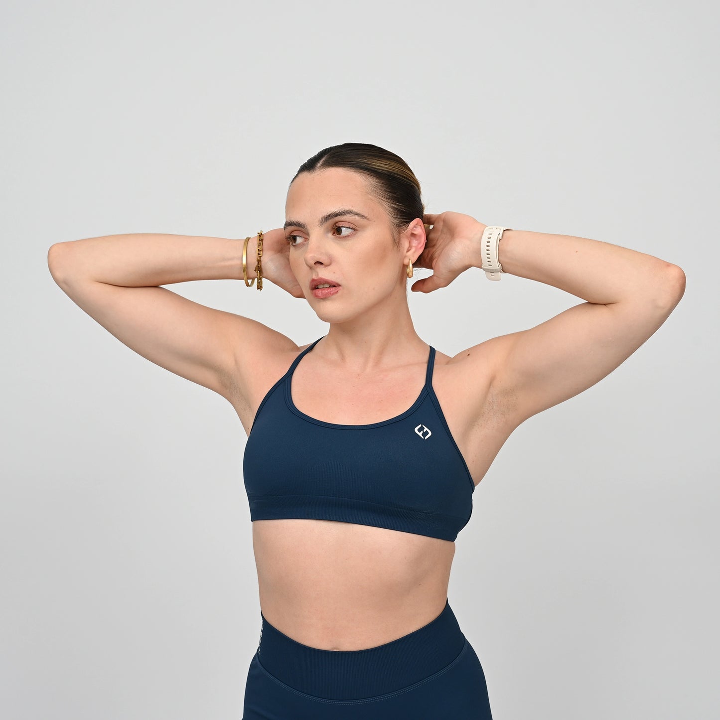 Woman wearing a teal Hybryd sports bra and matching leggings