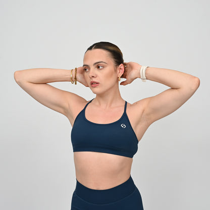 Woman wearing a teal Hybryd sports bra and matching leggings