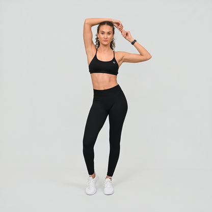 Girl wearing black Hybryd set. Equinox leggings that have a v-dip rear waist and a scrunch bum. Teamed with matching blac bra. From activewear brand Hybryd