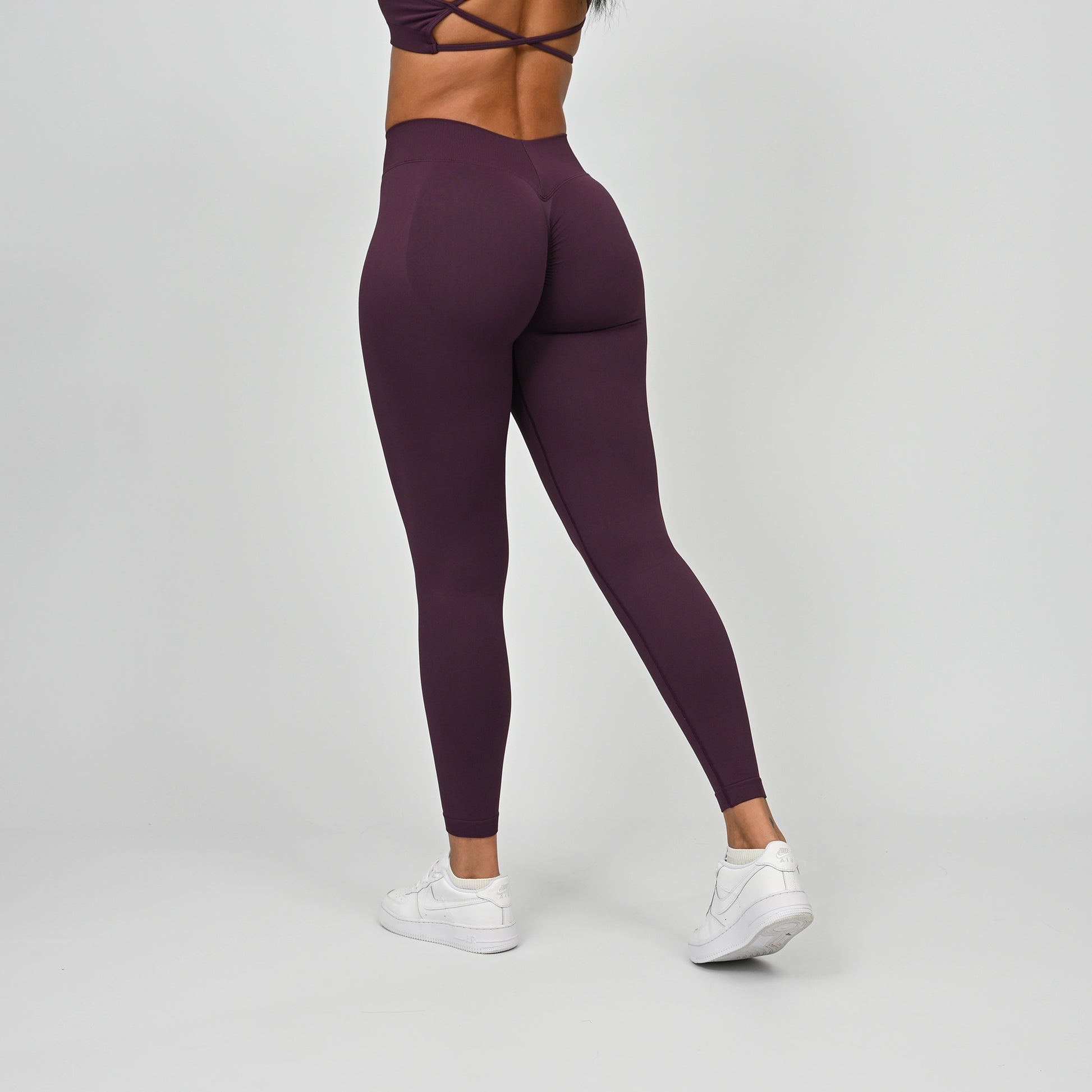 Gym girl wearing Hybryd equinox leggings that have a v-dip rear waist and a scrunch bum. From activewear brand Hybryd