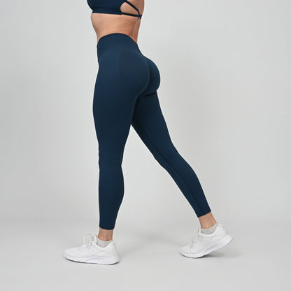 Girl wearing teal Hybryd equinox leggings that have a v-dip rear waist and a scrunch bum. From activewear brand Hybryd