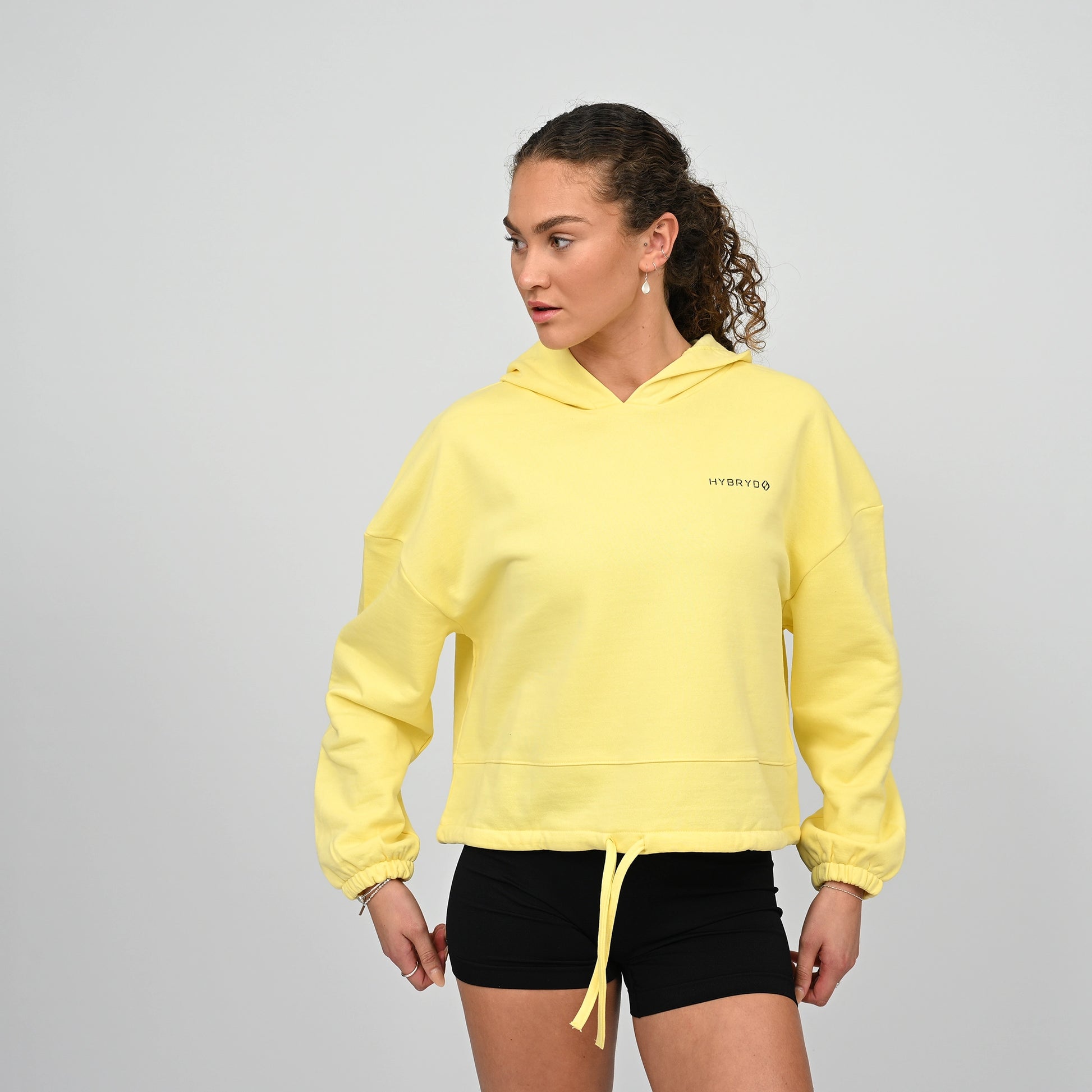 Woman wearing a Cropped oversized Hybryd hoodie. Dropped shoulders, oversized relaxed fit with a drawstring fastening