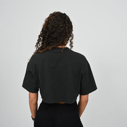 Person wearing a black Hybryd t-shirt from behind on a light grey background