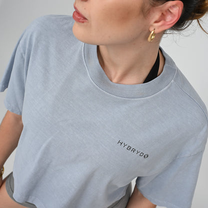 Person wearing a light blue t-shirt with 'HYBRYD' logo on a plain background