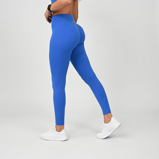 Person wearing blue active wear leggings with a hidden cinch on a plain background