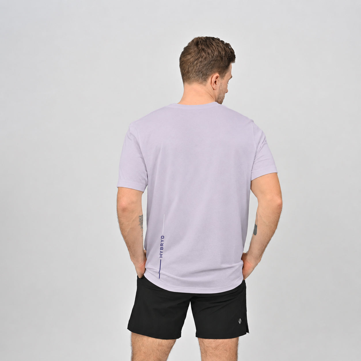 A Hyrox athlete wearing  cotton lilac T-shirt and black gym shorts from crossfit brand Hybryd