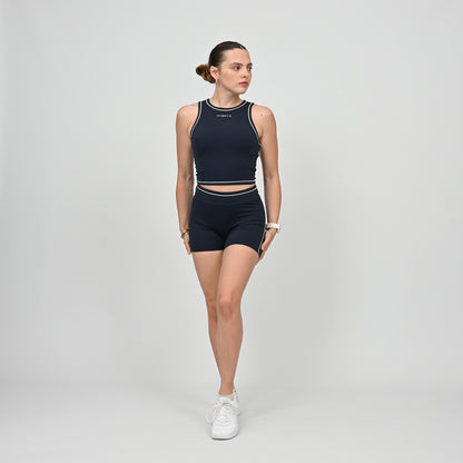 Hyrox model wearing a navy athletic gym top and shorts from Hybryd with white contrast piping.