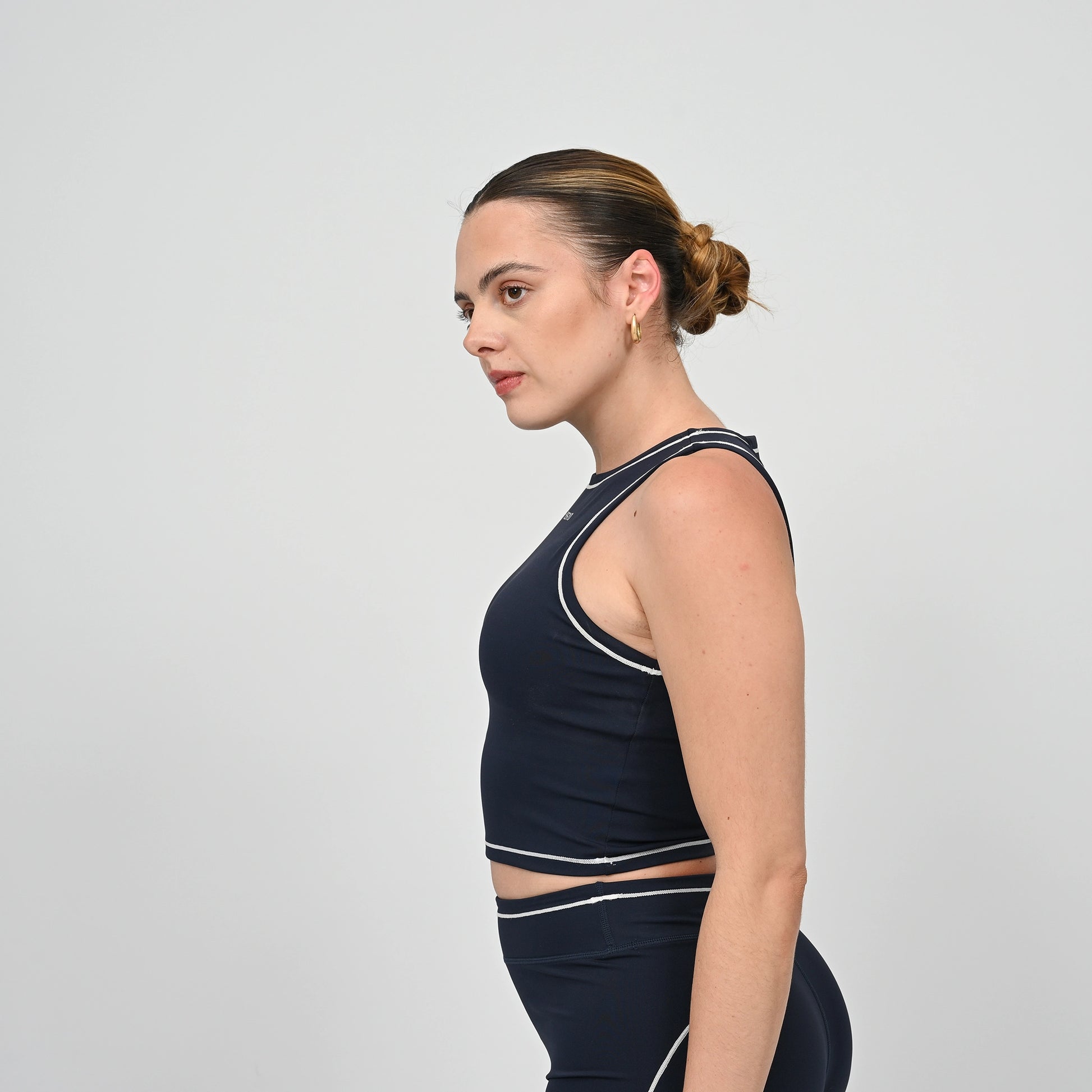Hyrox model wearing a navy athletic gym top from Hybryd with white contrast piping.