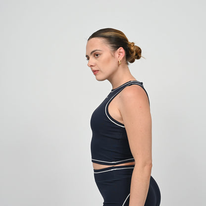 Hyrox model wearing a navy athletic gym top from Hybryd with white contrast piping.