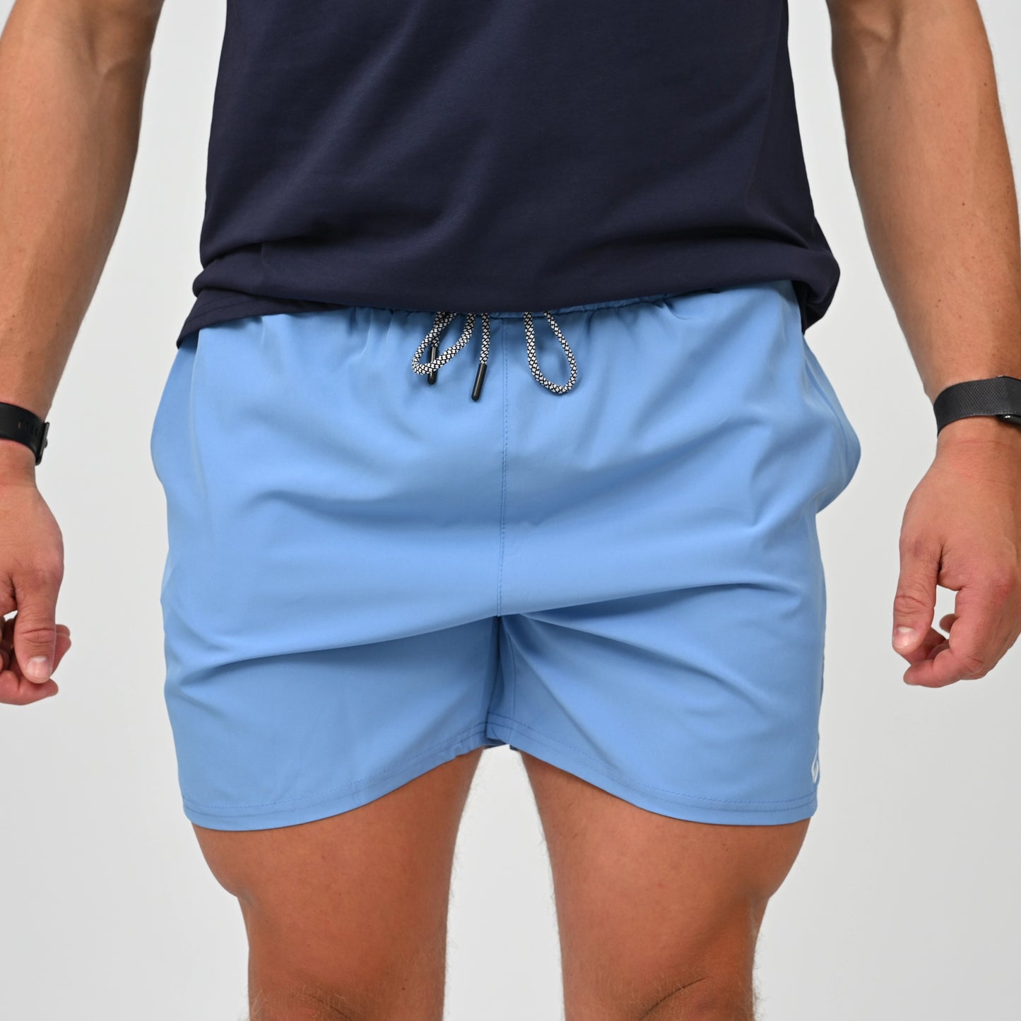 A crossFit athlete wearing a pair of swim shorts with draw string waist.  Worn with a navy gym tee. Made by activewear brand Hybryd.