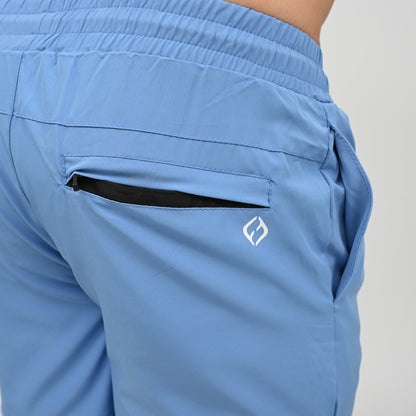 Close-up of a person wearing light blue athletic Hybryd shorts, showing the back pocket with a black interior lining and a small white Hybryd logo on the side.