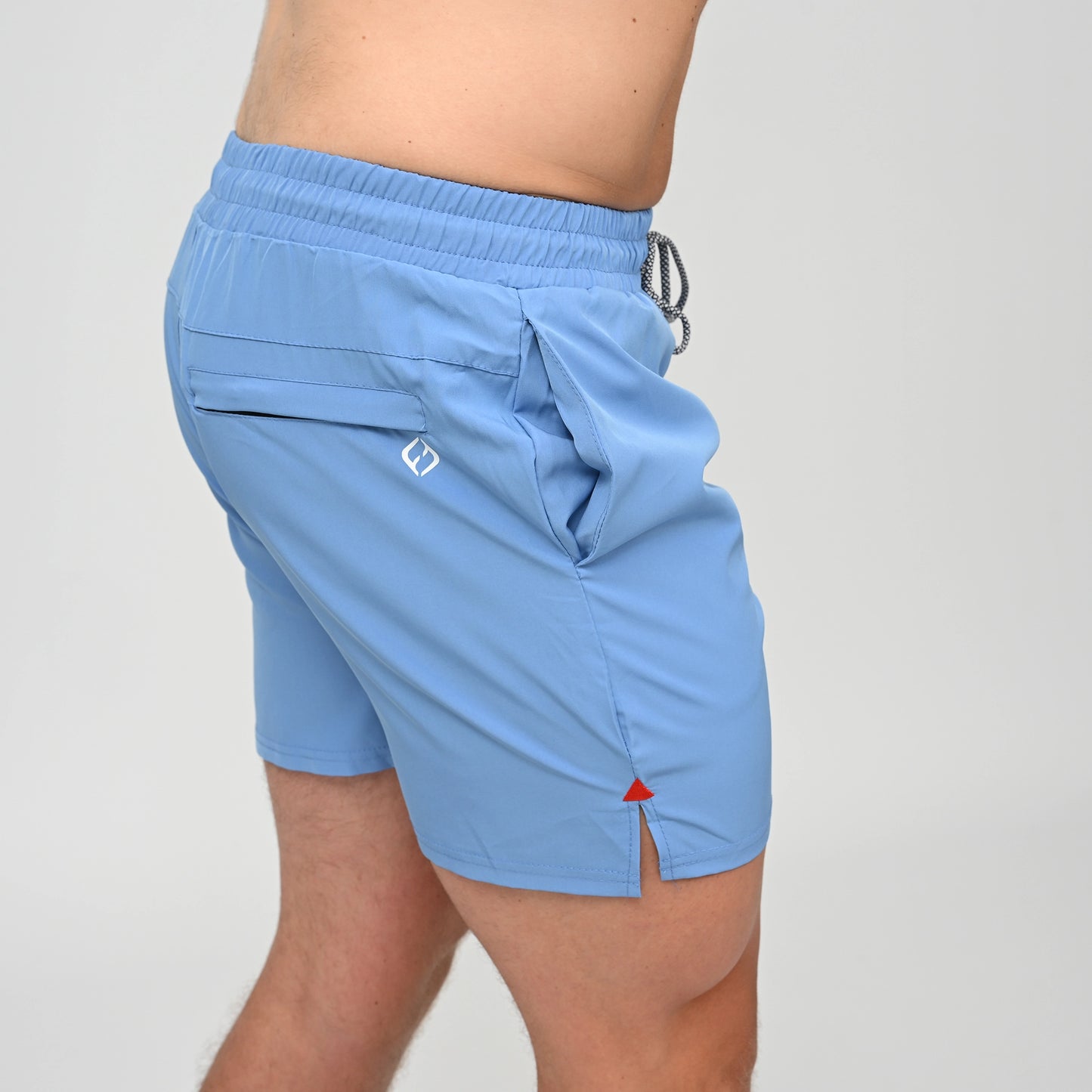 A crossFit athlete wearing a pair of swim shorts with drawstring waist. A side view showing side pockets and rear zip pocket. Made by activewear brand Hybryd.