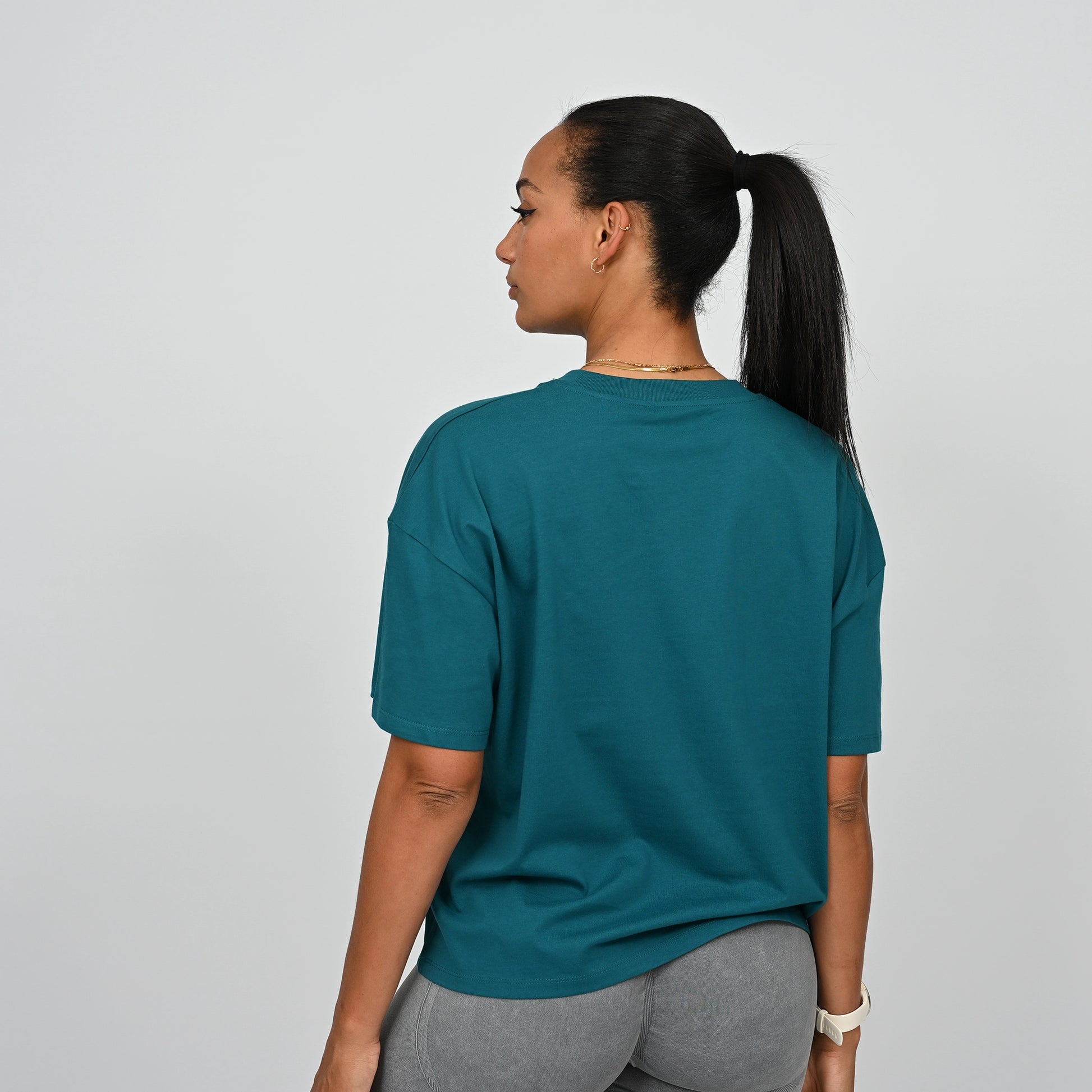 Person wearing a teal Hybryd t-shirt on a plain background